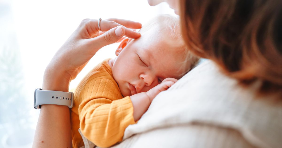 Kisbaba anyja mellkasán alszik