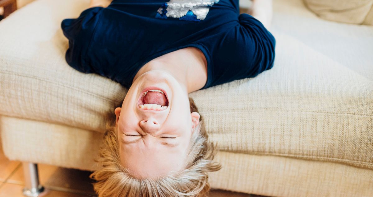 fejjel lefelé a kanapén hisztiző szőke kisfiú