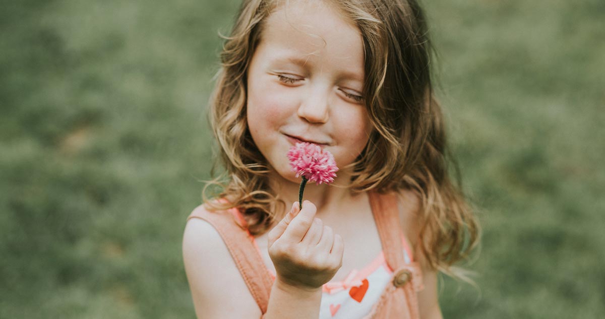 kislány virágot tart a kezében