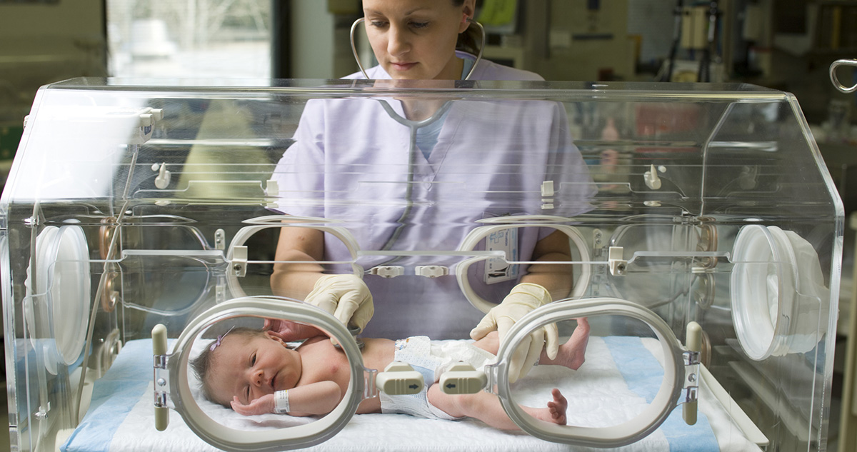 Koraszülött baba inkubátroban az orvos vizsgálja