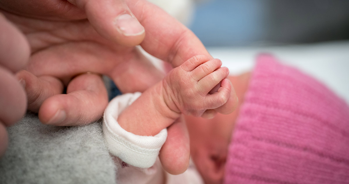 Koraszülött baba felnőtt ujjat fog