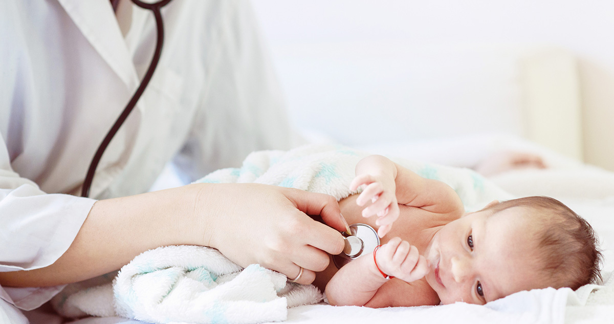 Gyermekorvos vizsgálja az újszülöttet sztetoszkóppal