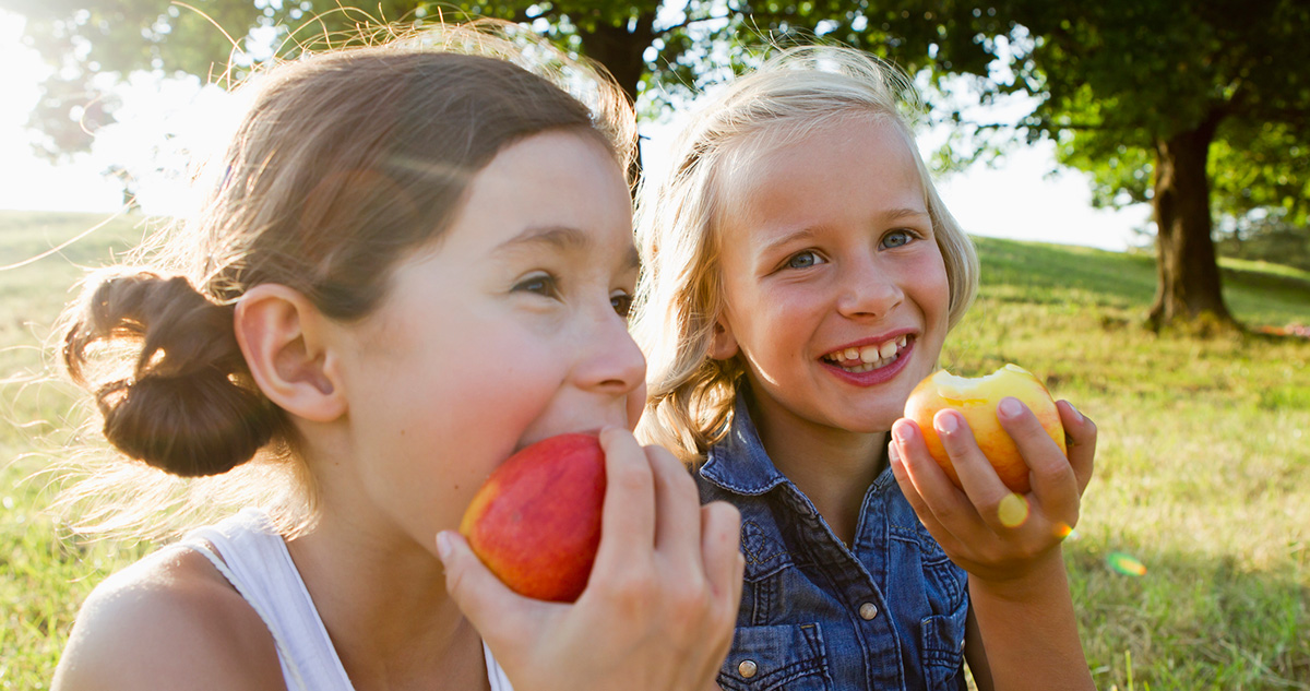 Lányok almát esznek a természetben