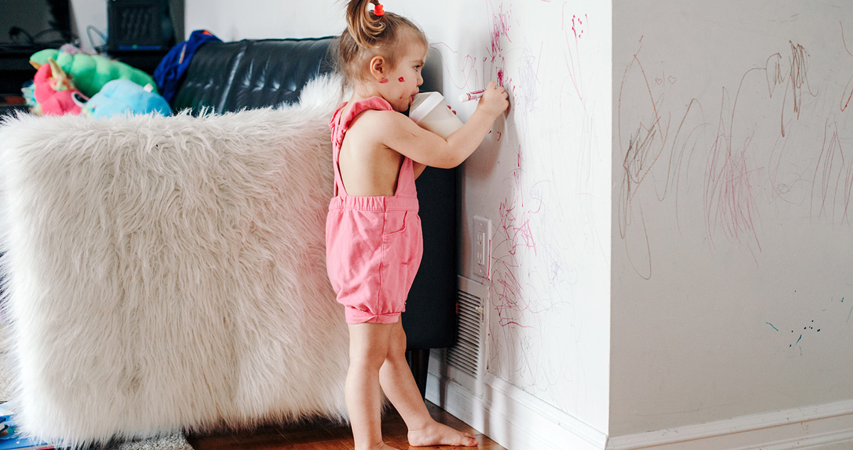 Kislány falra rajzol a nappaliban