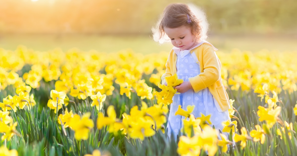 Kislány tavaszi virágok között