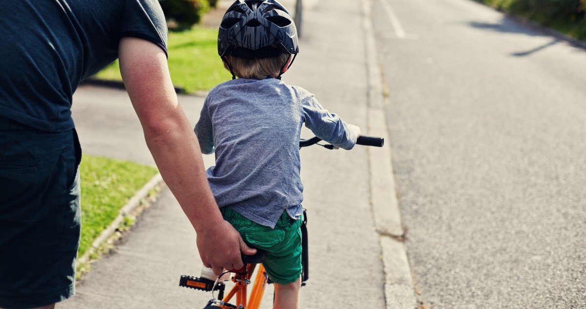 Biciklizni tanul egy kisfiú az apukájával