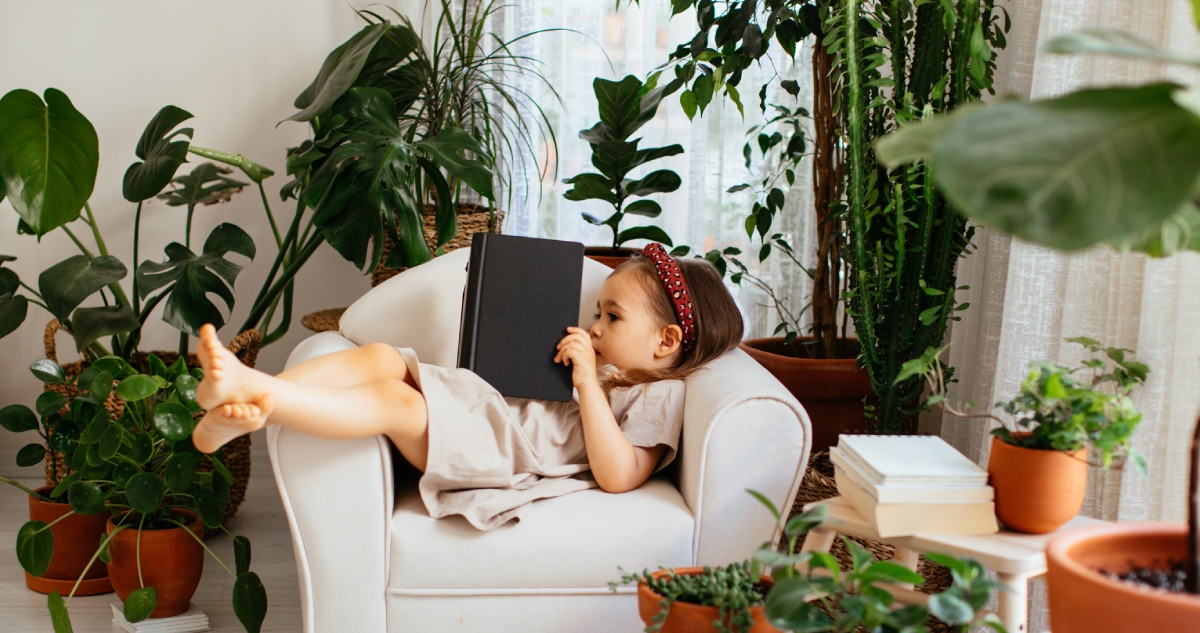 Kislány olvas a növények között