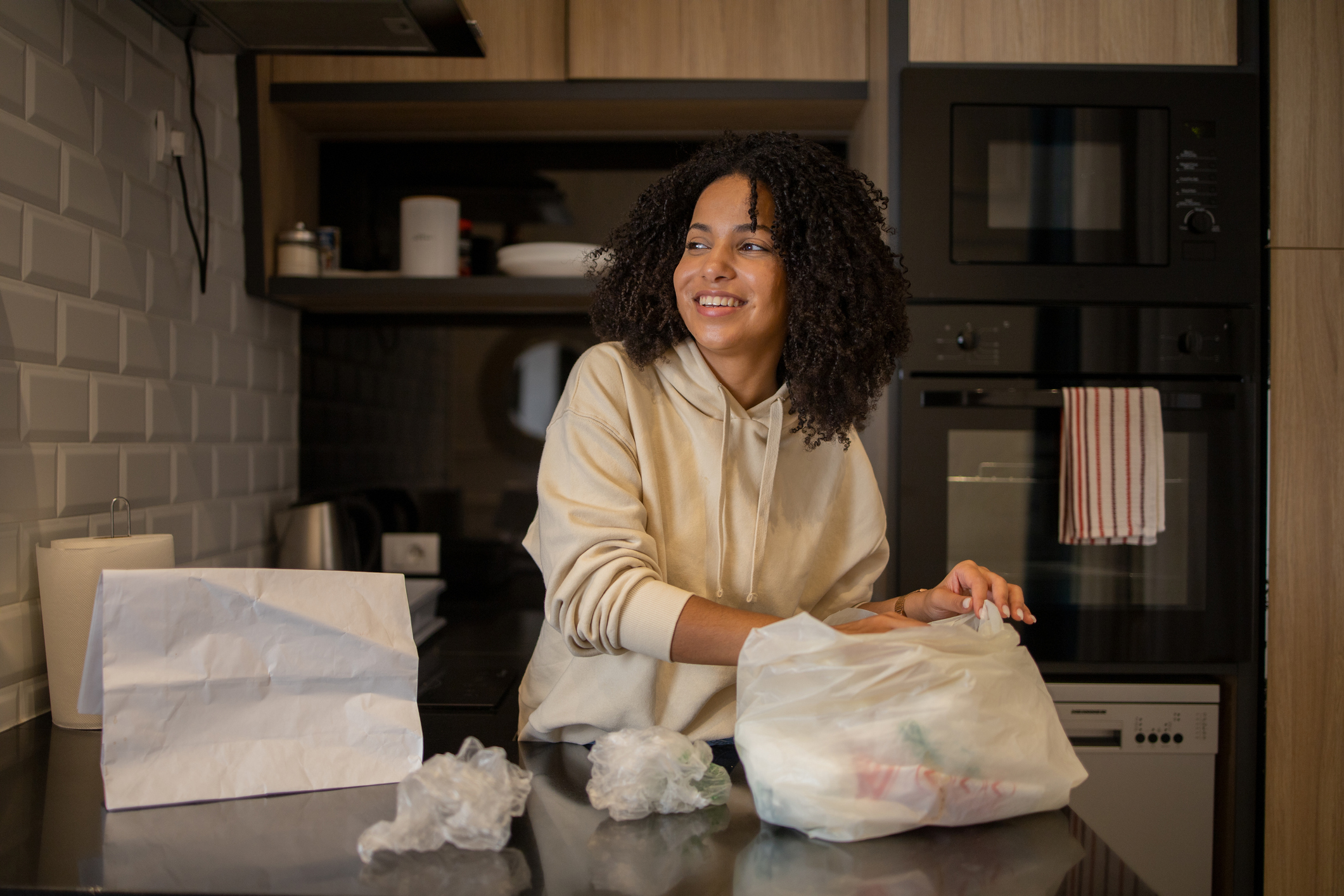 Nő konyhában műanyag zacskókat pakol