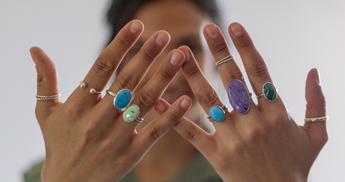 Női kéz színes gyűrűkkel