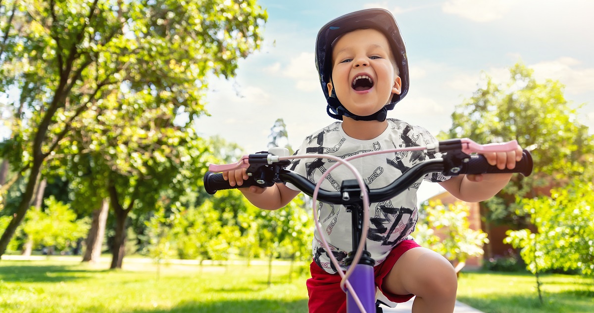 kisfiú boldogan biciklizik