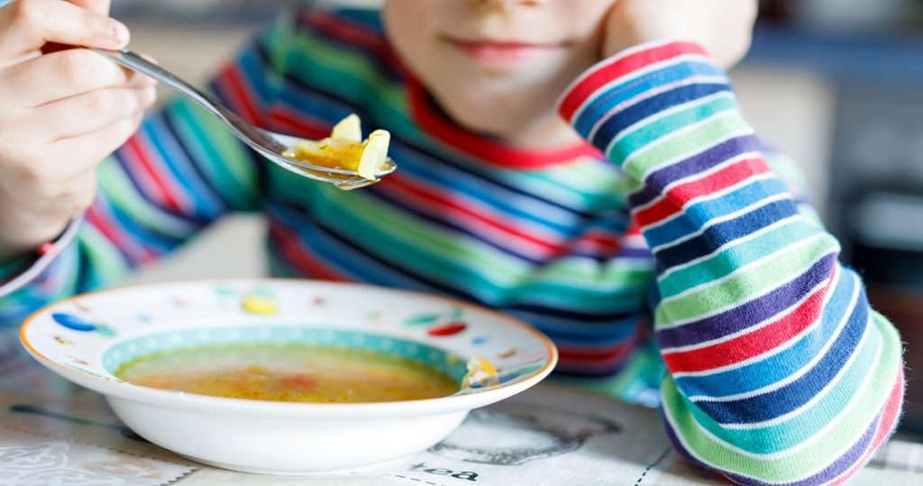 Kislány forró levest eszik