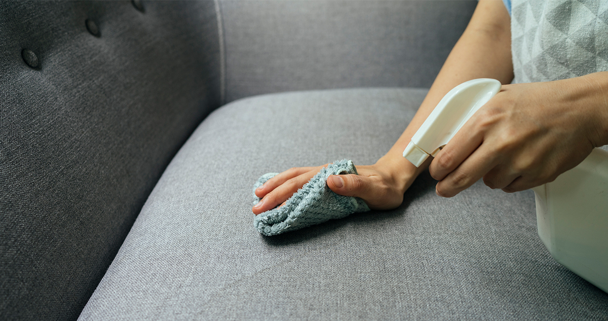 Nő textil kanapét tisztít mikroszálas kendővel