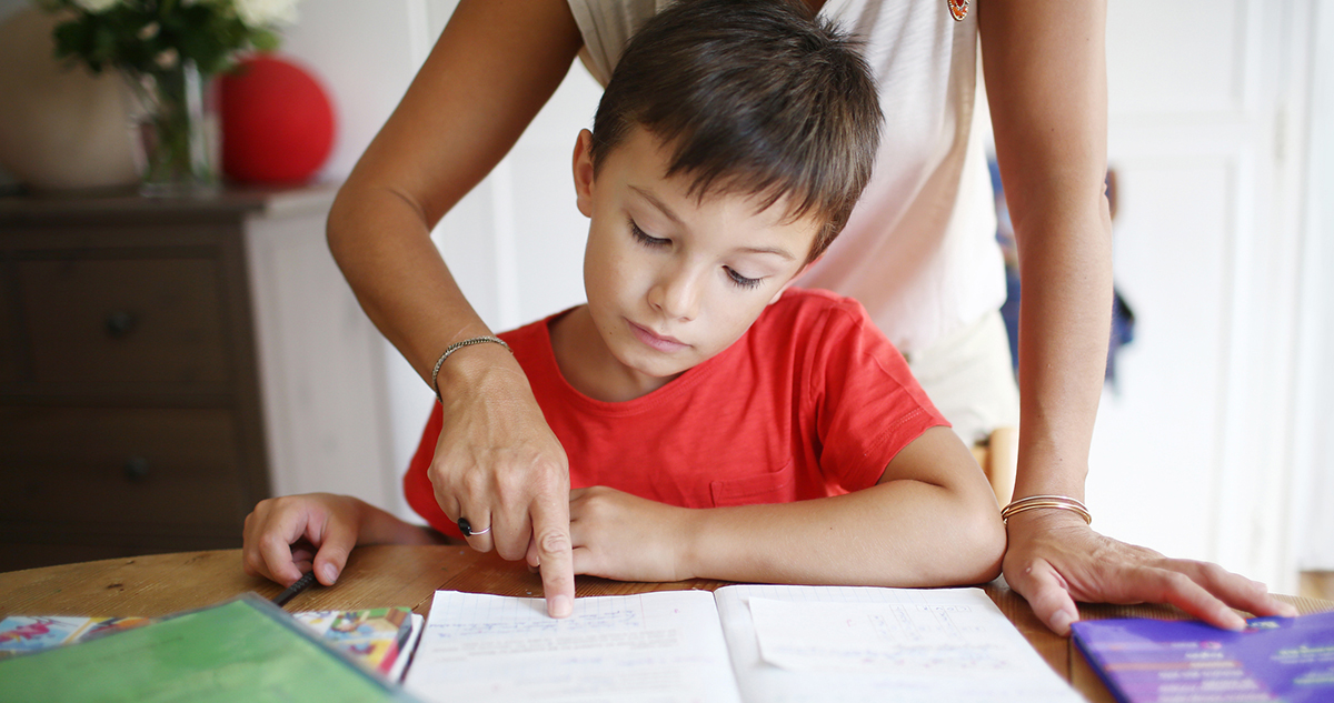 kisfiú anyukájával tanul, leckét ír