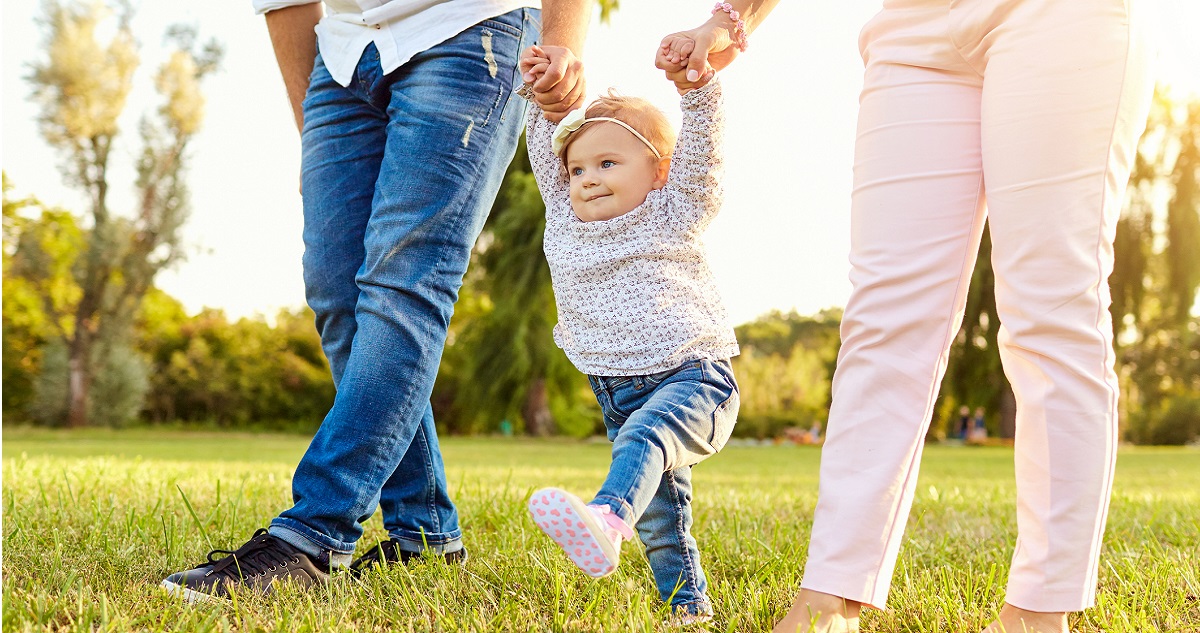 kislány a szüleivel sétál a tavaszi mezőn