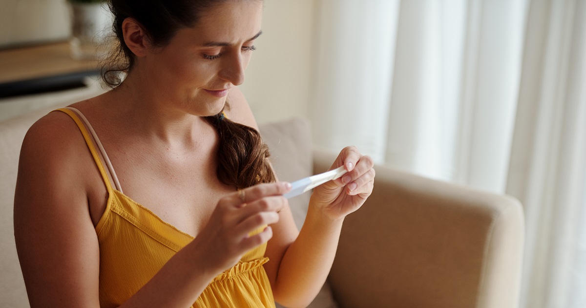 nő terhességi teszttel a kezében