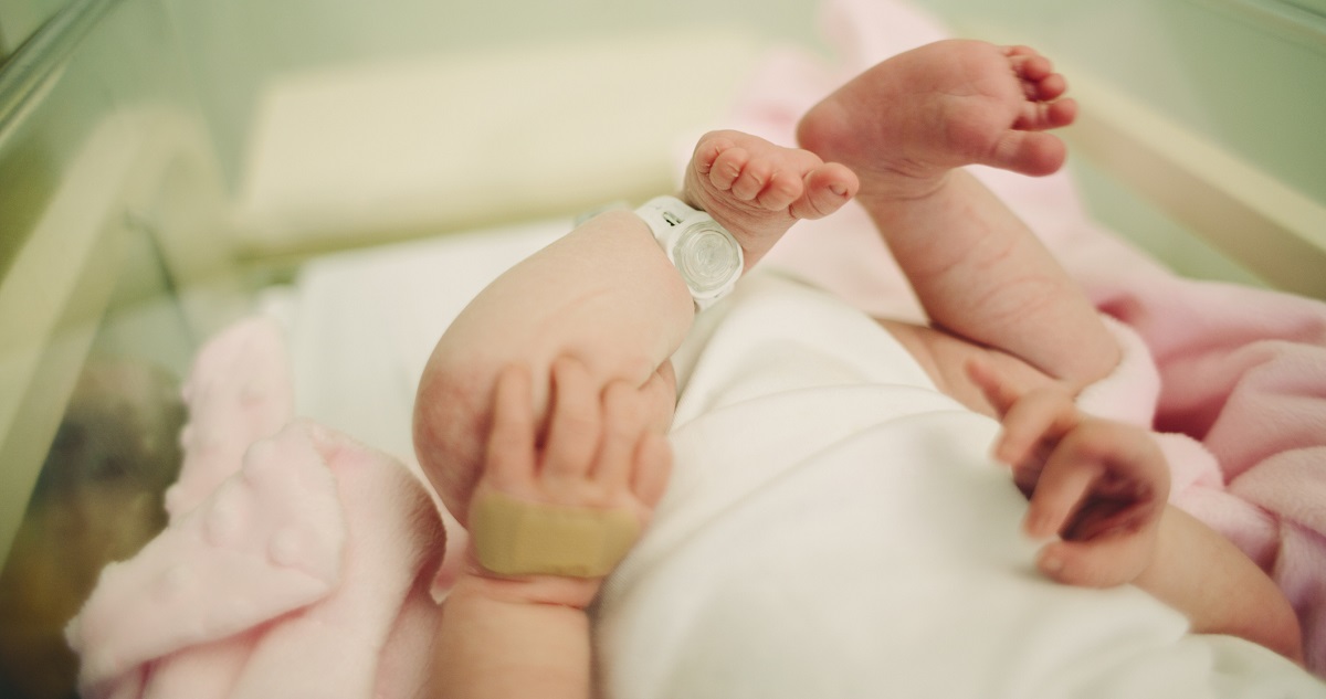 View of baby's feet with a hospital security tag on