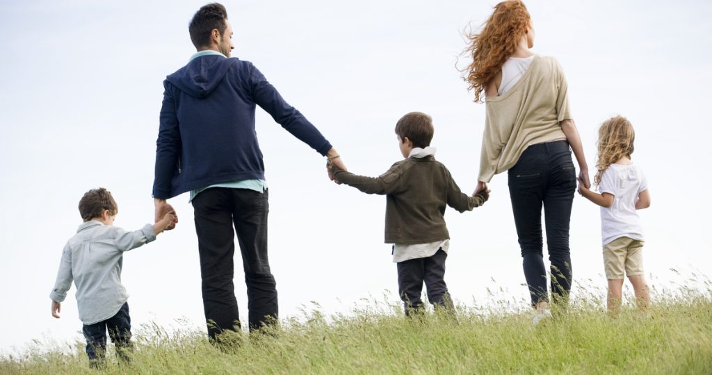 szülők három kisgyerekkel sétálnak kézen fogva