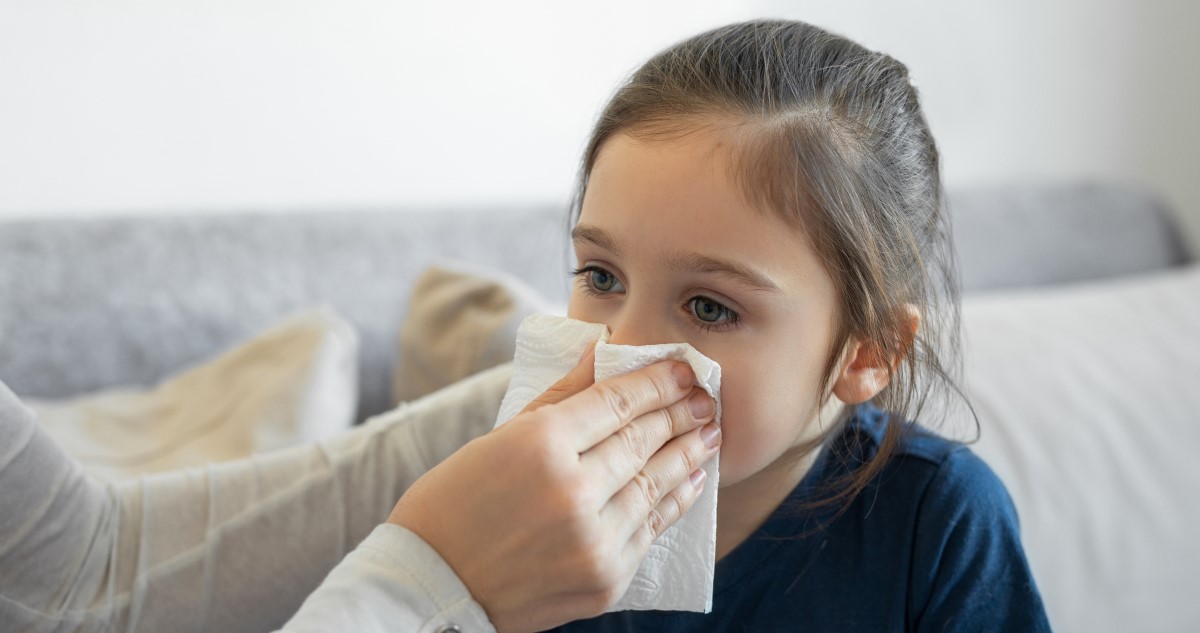 anya zsebkendőt fog a kislánya orrához