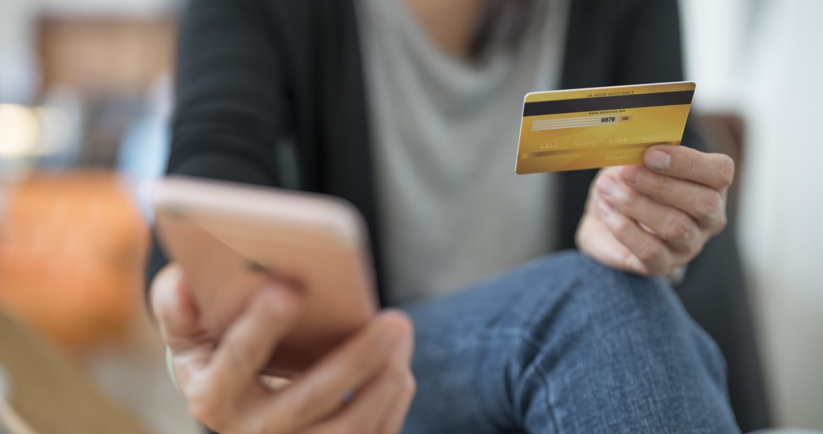 nő telefonnal és bankkártyával