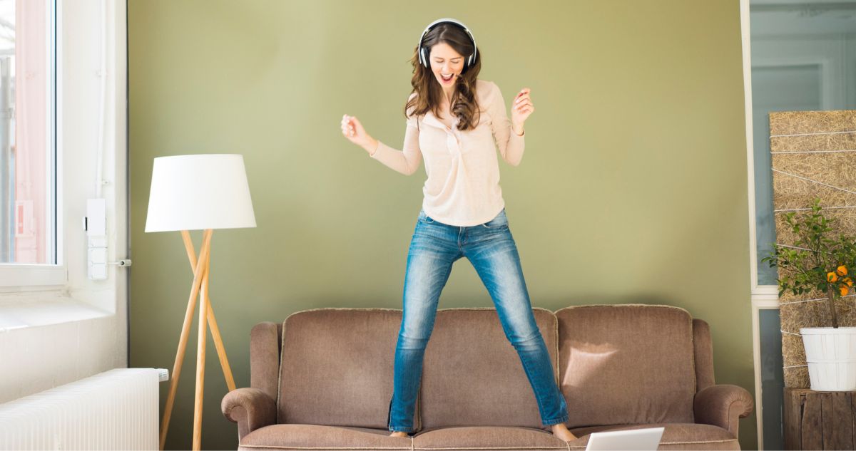 nő zenére táncol a kanapén