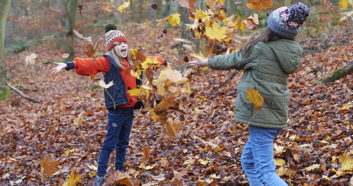 kislányok játszanak ősszel falevelekkel