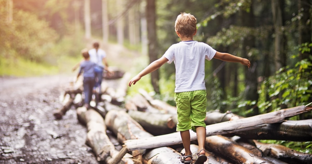 kisfiú erdőben sétál a családjával