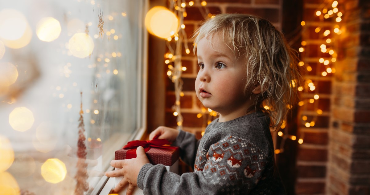 kisgyerek ajándékkal télen