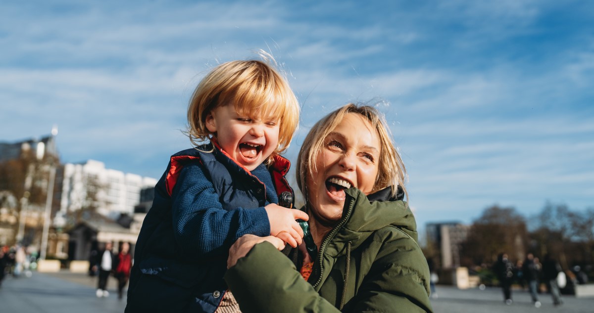 anya és kisfia télen a városban nevetnek