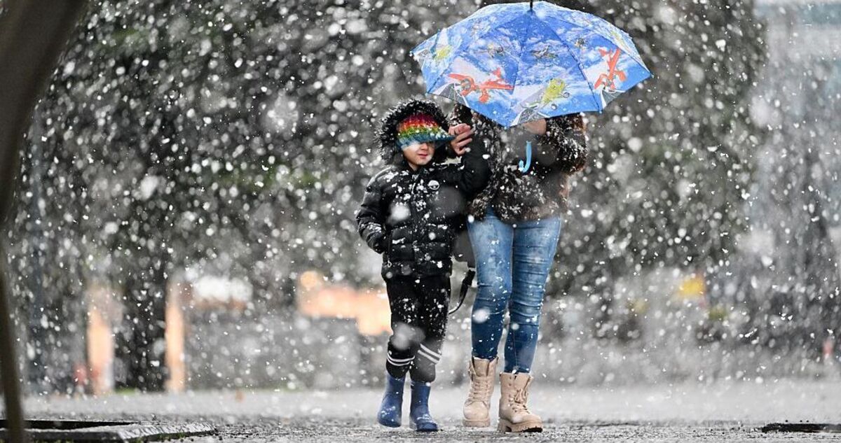 kisfiú megy az anyukájával a hóesésben - fotó: Getty