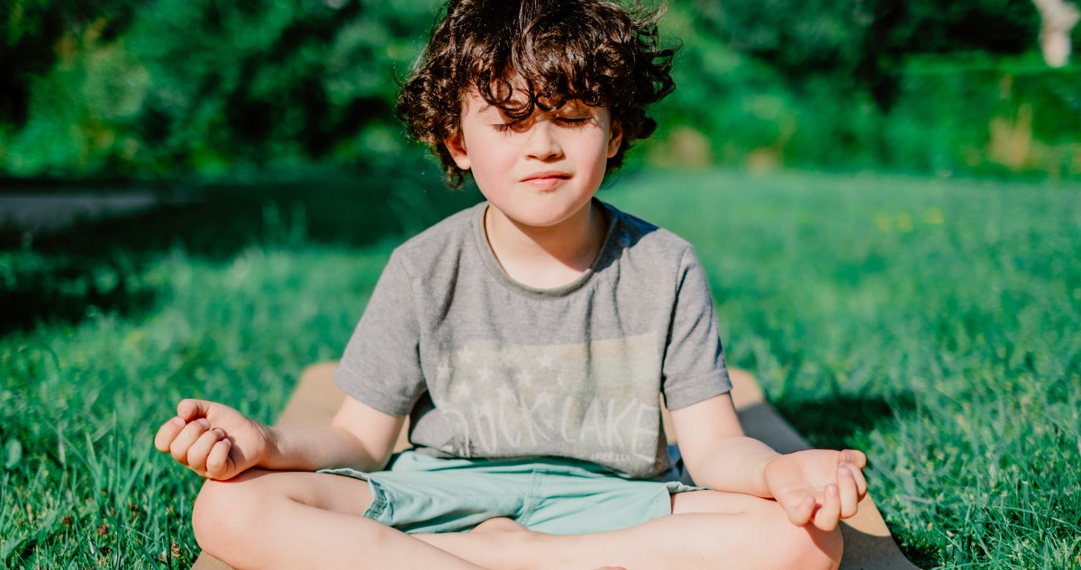 meditáló kisfiú a kertben ül