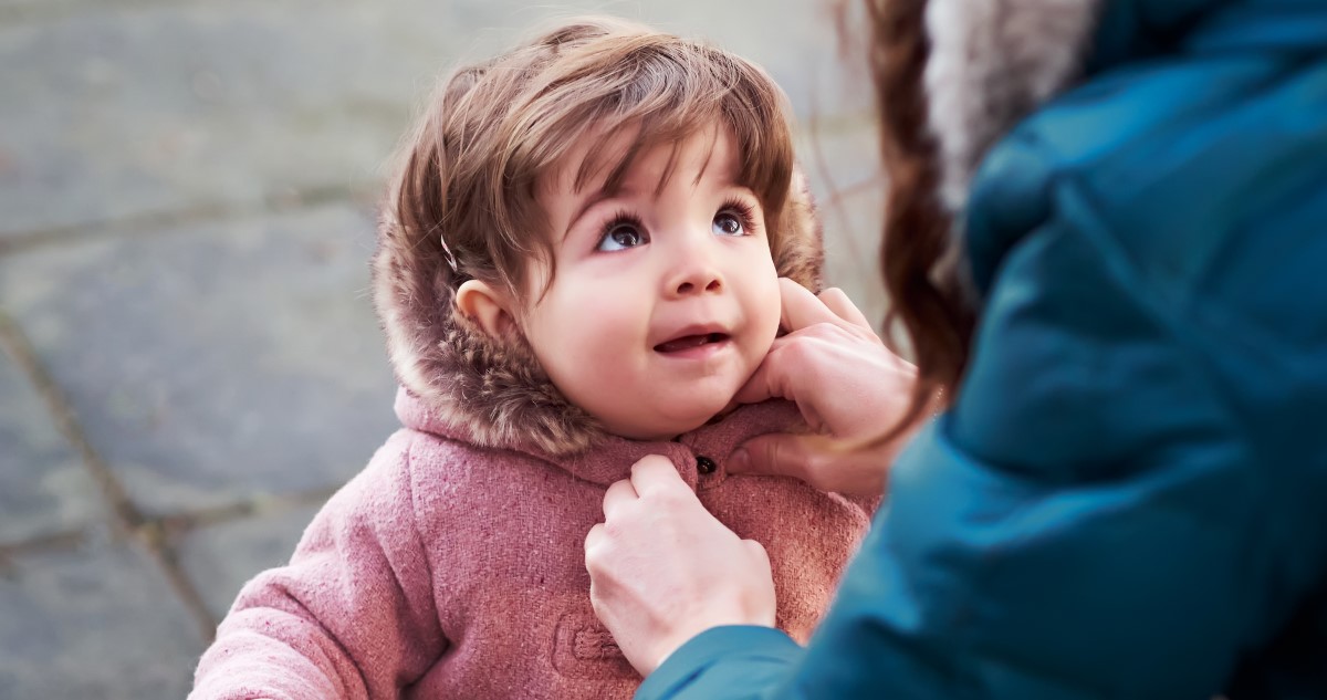 anya kisgyereket öltöztet kabátba
