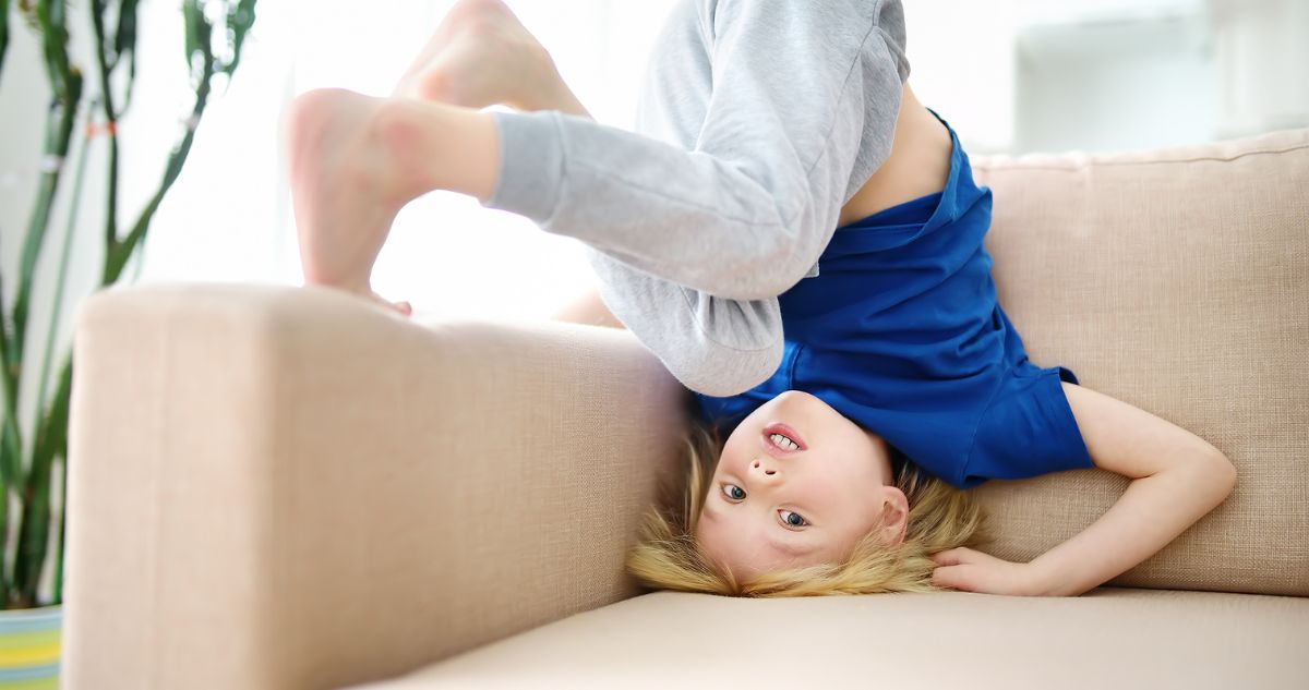 kisfiú fejenáll a kanapén