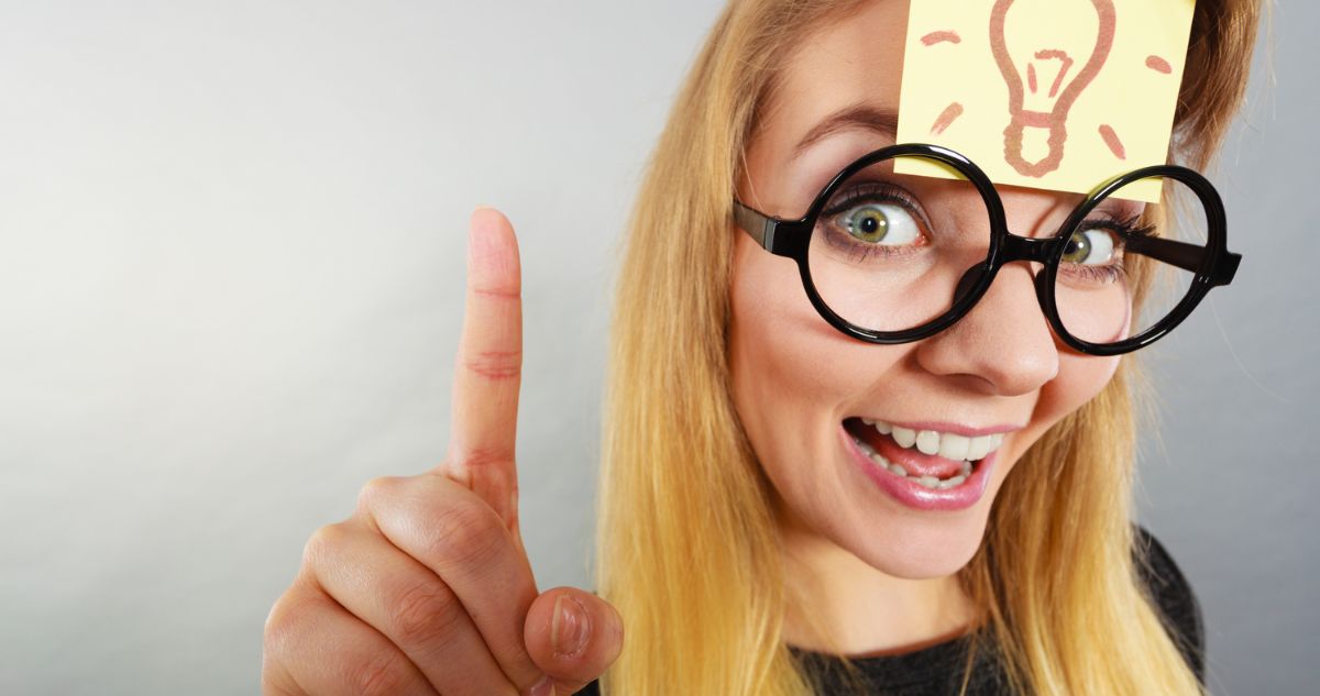 Szemüveges nő ujjával felfelé mutat
