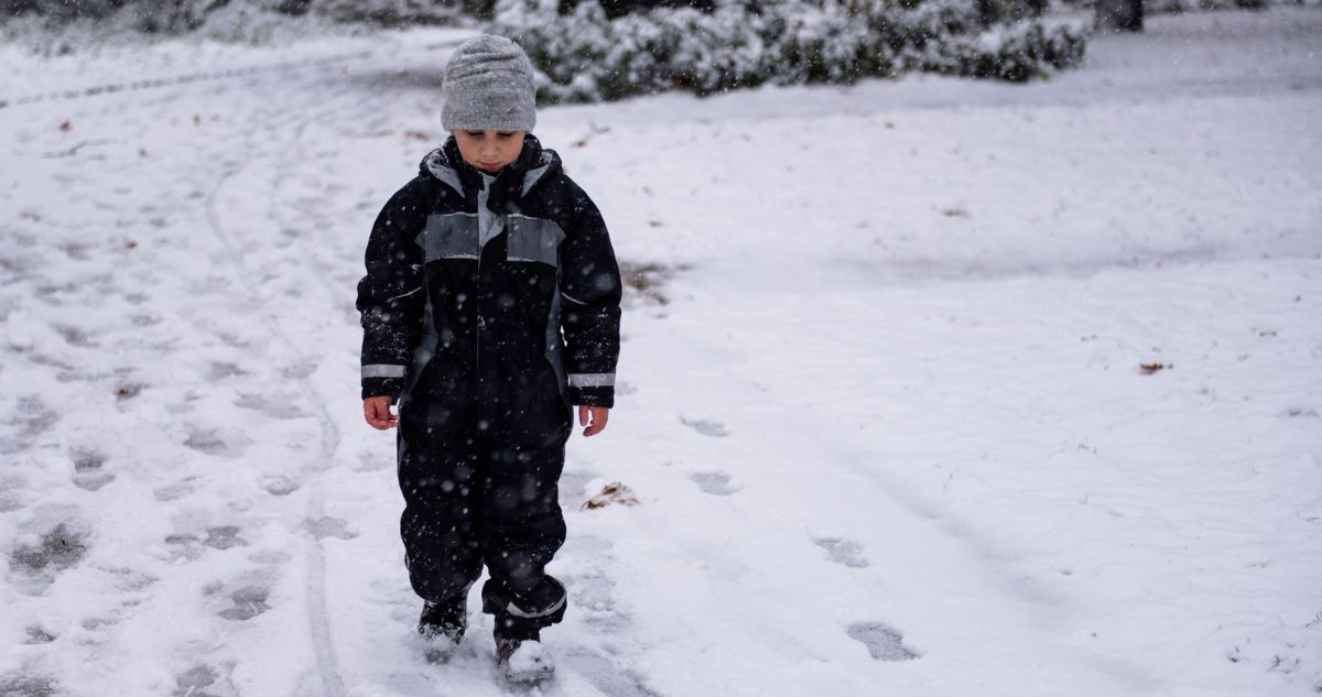 Kisfiú egyedül gyalogol a hóban