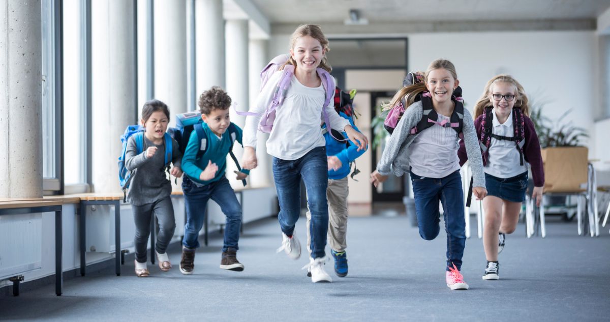 iskolasok - Gyerekszoba gyerekek iskolatáskával a hátukon futnak felénk nevetve az iskolában