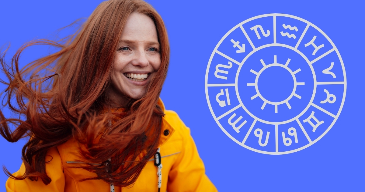 Nő sárga kabátban mosolyog egy horoszkóp ábra mellett