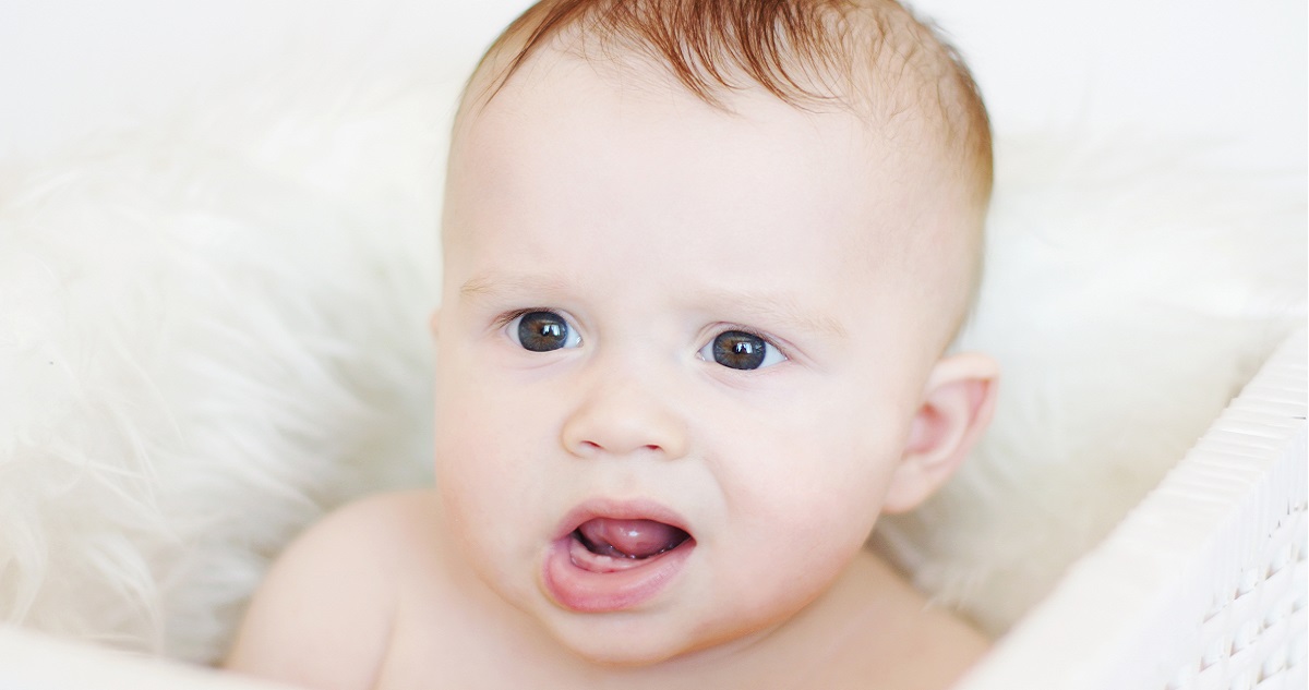 Vörös hajú kisbaba grimaszol