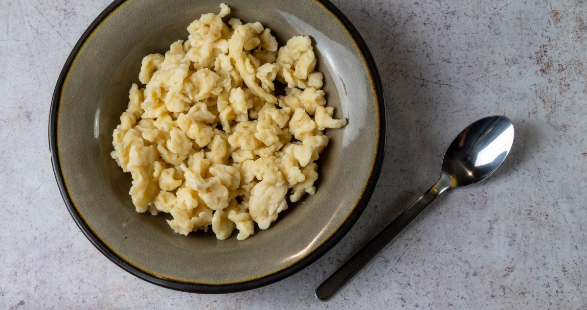 nokedli egy szürke tányéron, kanállal