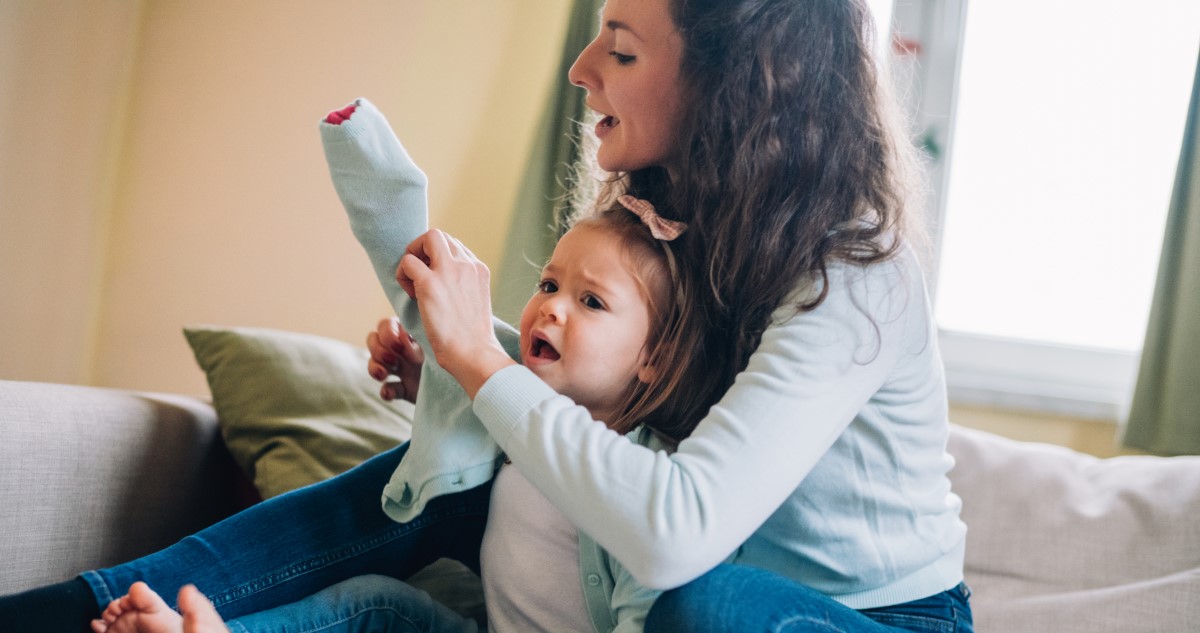 kisgyereket öltözteti az anyukája
