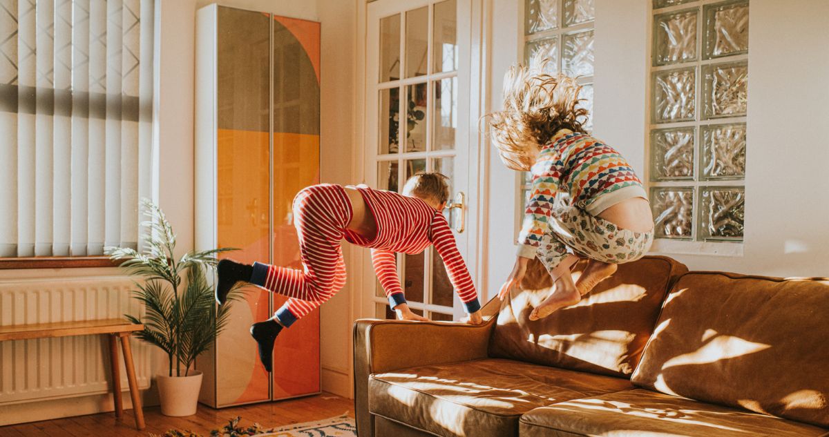 gyerekek pizsamában a kanapén ugrálnak