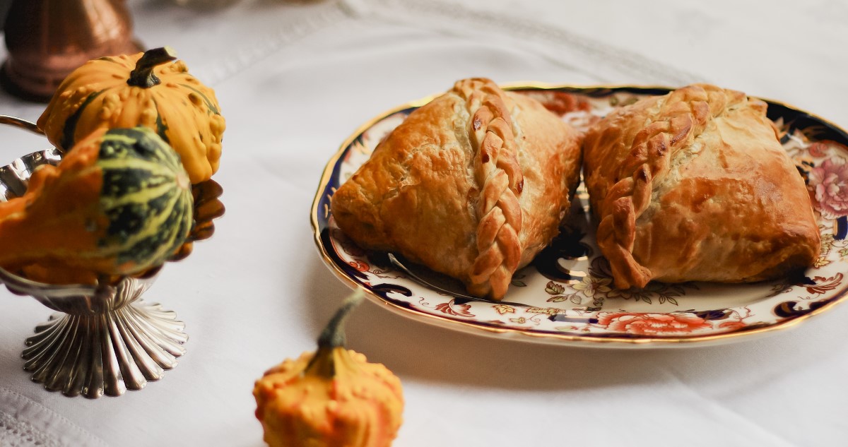 réteslapba csomagolt wellington hús egy asztalon, tányéron, dísztökökkel körbevéve