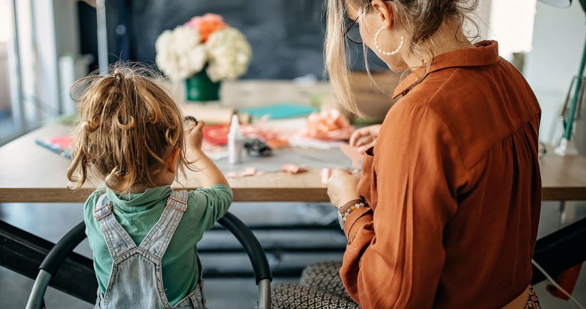 anya gyerekével kézműveskedik asztalnál