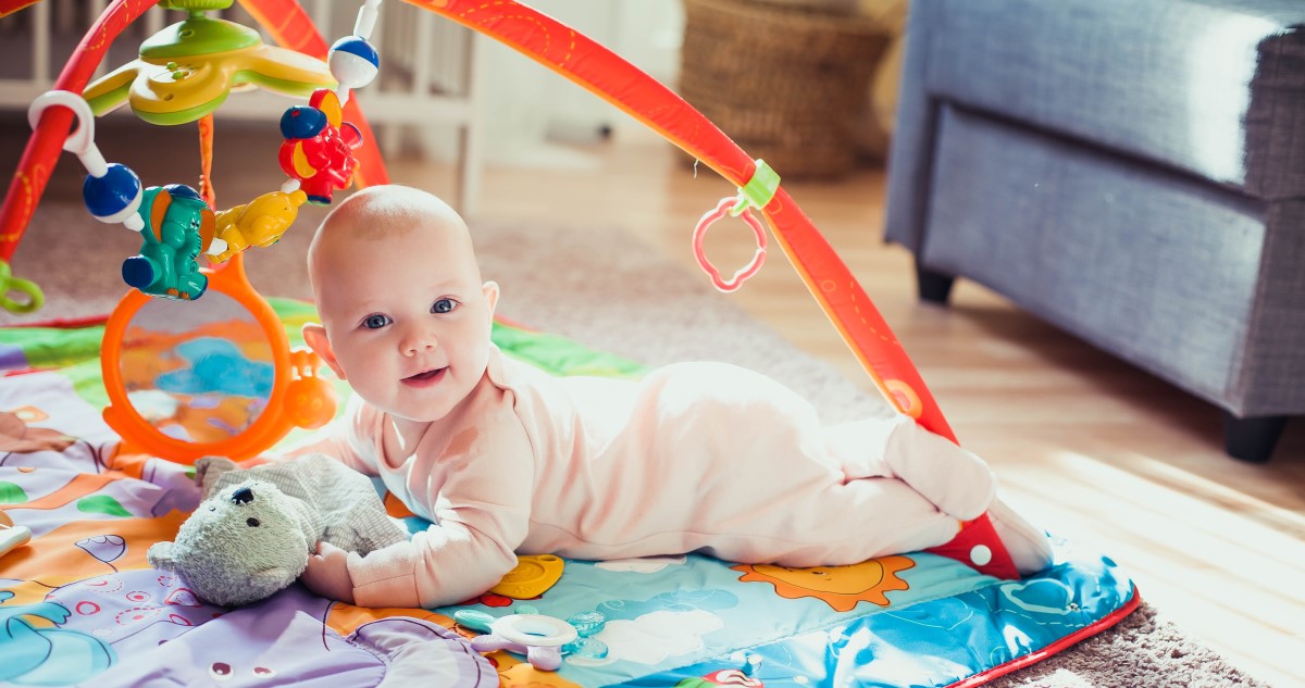 kisbaba játszószőnyegen hason fekszik