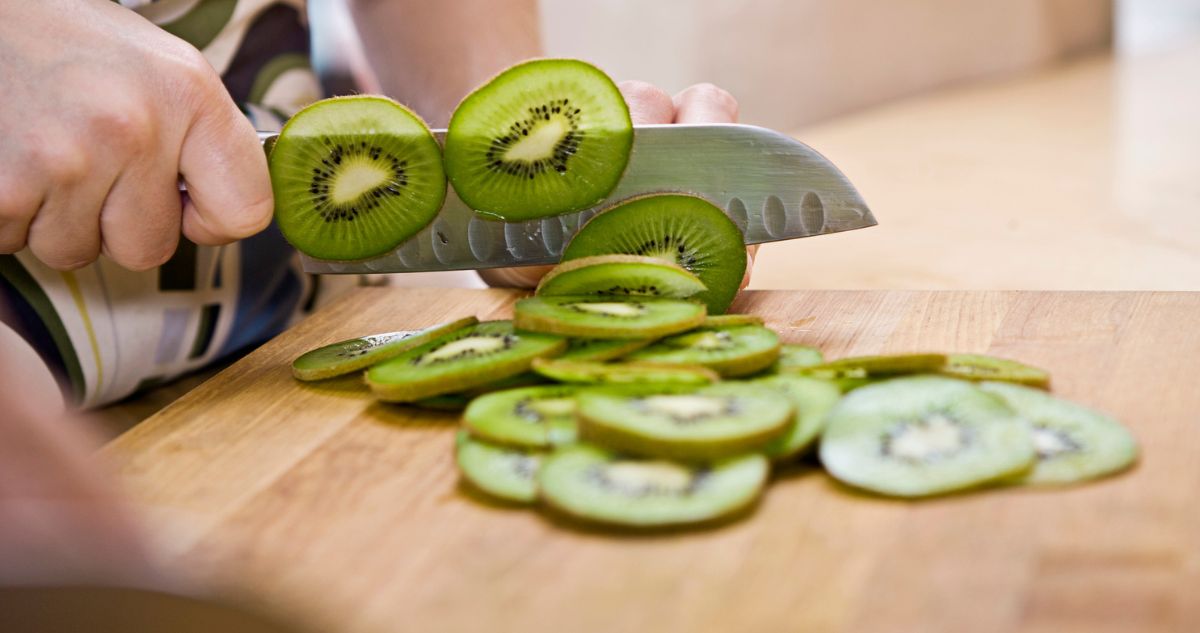 Nő késsel kivit szeletel