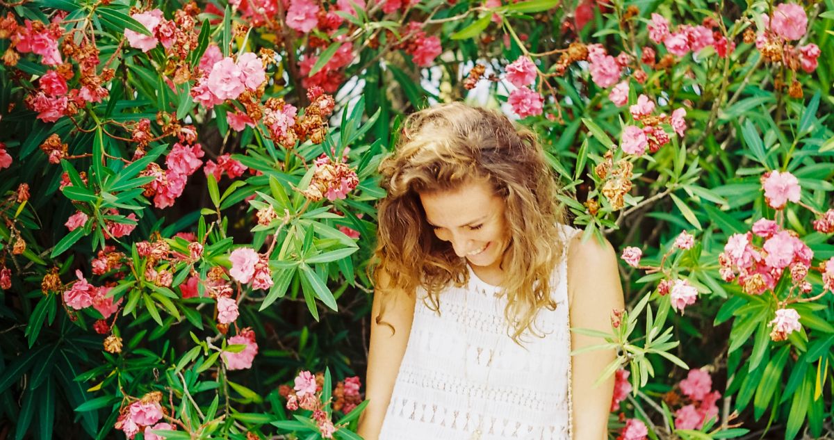 nő mosolyog leanderek között