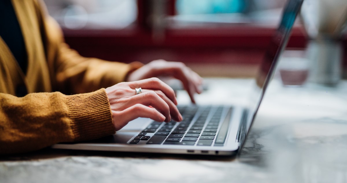 női kéz laptop billentyűzeten