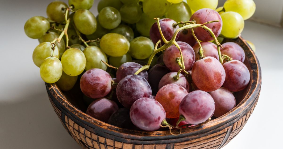 Közeli kép egy tányér fehér és piros szőlőről