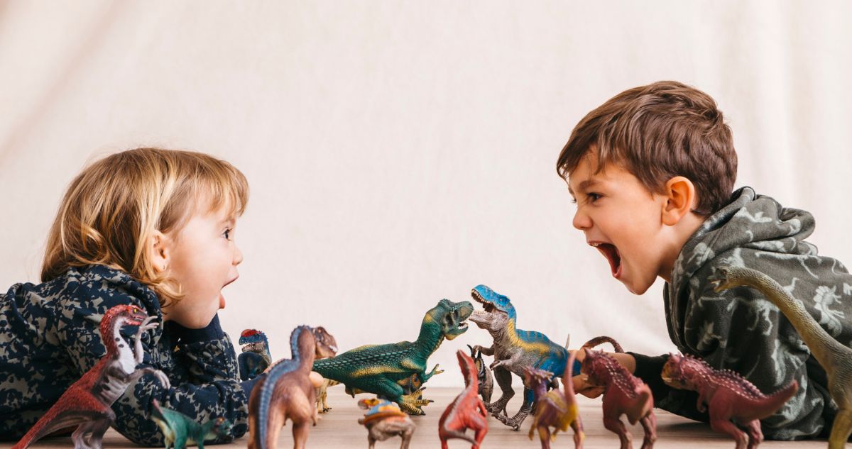 gyerekek játszanak dinókkal, az egyik kiabál