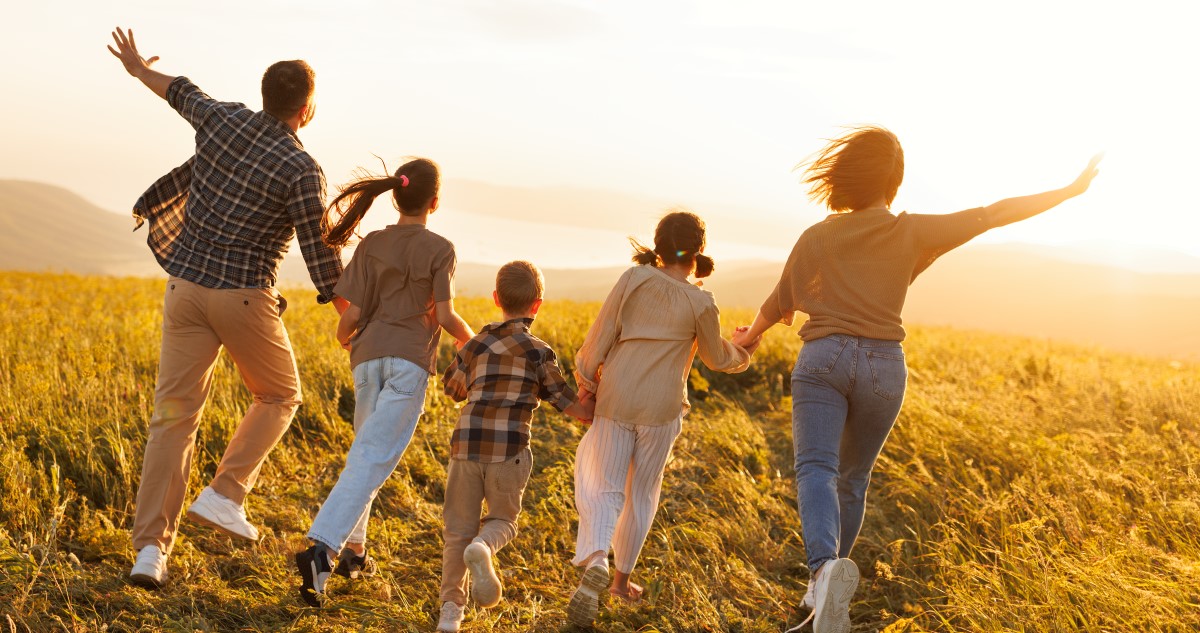 nagy család sétál a mezőn naplementekor