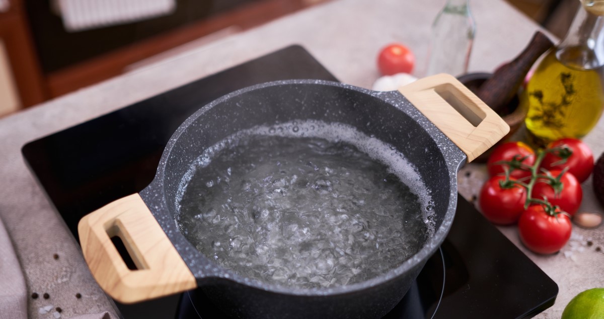 forr a víz egy szürke fazékban indukciós főzőlapon